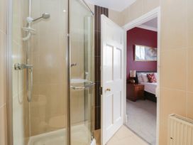 A bathroom with a shower and doorway to a bedroom at 8 Corkickle, Whitehaven