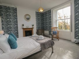 A bedroom with a bed and chair at 8 Corkickle Whitehaven