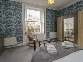 A bedroom with a bed and a rocking chair at 8 Corkickle Whitehaven