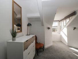 A room with a mirror, lamp, dresser, and armchair at 8 Corkickle, Whitehaven