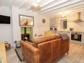 A living room with a sofa and fireplace at Riverside Cottage in Conwy
