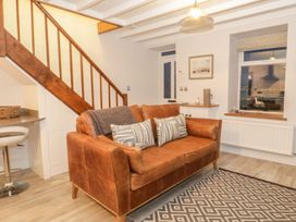 A living room with a sofa and staircase at Riverside Cottage in Conwy