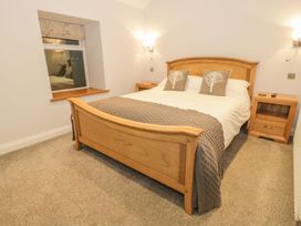 A bedroom with a wooden bed and bedside tables at Riverside Cottage in Conwy