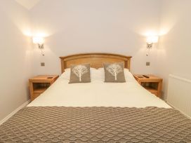 A bedroom with a bed and bedside tables at Riverside Cottage in Conwy