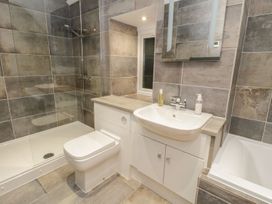 A bathroom with bathtub, shower, sink, and toilet at Riverside Cottage in Conwy