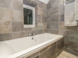 A bathroom with a bathtub and towel rack at Riverside Cottage in Conwy
