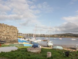 A view of boats on water near a rock wall at Riverside Cottage in Conwy