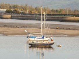 A boat in the water near a sandy riverbank at Riverside Cottage in Conwy