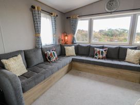 A living room with a sectional sofa and large window at Ellies House in Stranraer