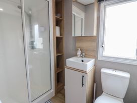 A bathroom featuring a shower, toilet, and sink at Ellies House in Stranraer