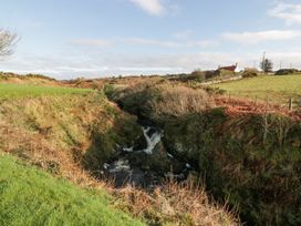 A landscape with a waterfall and a house in the background at Ellies House Stranraer