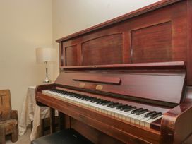 A piano with a lamp and table in a living room at Castle Terrace in Penrith