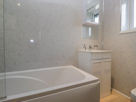 A bathroom with a bathtub and sink at Castle Terrace Penrith