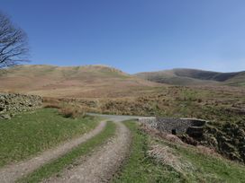 A road leading to a stone building near mountains at Castle Terrace Penrith