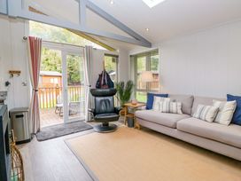 A living room with a sofa, chair, and coffee table at 5 Waterside Wood in Troutbeck Bridge