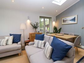 A living room with a sofa and a dining table at 5 Waterside Wood Troutbeck Bridge