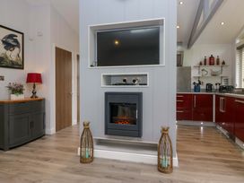A living room with a fireplace and television at 5 Waterside Wood Troutbeck Bridge