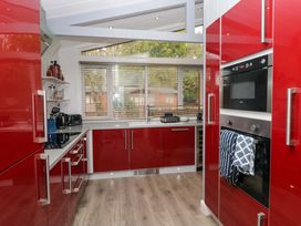 A kitchen with red cabinets and appliances at 5 Waterside Wood Troutbeck Bridge