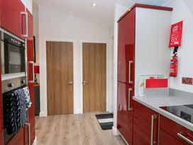 A kitchen with appliances and doors at 5 Waterside Wood Troutbeck Bridge
