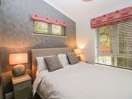 A bedroom with a bed and lamps at 5 Waterside Wood Troutbeck Bridge