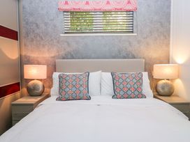 A bedroom with a bed and bedside tables at 5 Waterside Wood in Troutbeck Bridge