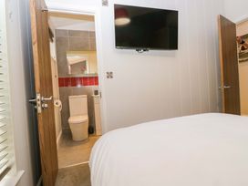 A bedroom with a bed and an adjoining bathroom at 5 Waterside Wood in Troutbeck Bridge