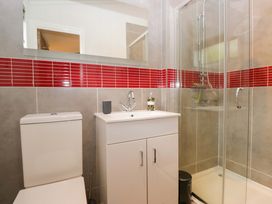 A bathroom with a shower, sink, and toilet at 5 Waterside Wood Troutbeck Bridge