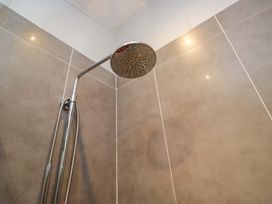 A shower head with tiles in the bathroom at 5 Waterside Wood Troutbeck Bridge