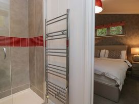 A bathroom with a shower and towel rail at 5 Waterside Wood in Troutbeck Bridge