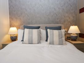 A bedroom with a bed, pillows, and lamps at 5 Waterside Wood Troutbeck Bridge