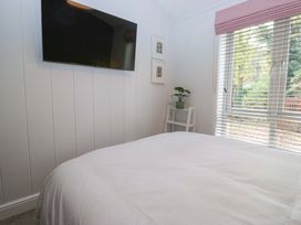 A bedroom with a bed and television at 5 Waterside Wood Troutbeck Bridge
