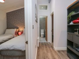 A bedroom with twin beds and a view of the hallway at 5 Waterside Wood Troutbeck Bridge
