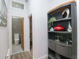 A hallway with a shelf and a view of a bathroom at 5 Waterside Wood Troutbeck Bridge
