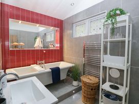 A bathroom with a bathtub and sink at 5 Waterside Wood Troutbeck Bridge