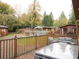 An outdoor area with cabins and seating at 5 Waterside Wood in Troutbeck Bridge