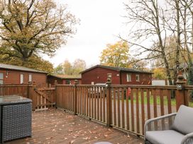 An outdoor area with decking and wooden railing at 5 Waterside Wood Troutbeck Bridge