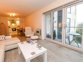 A living room with a sofa and dining area at Heulfan in Conwy