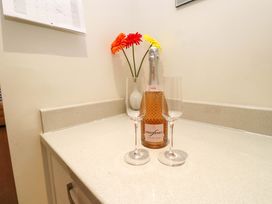 A kitchen counter with a champagne bottle and glasses at Heulfan in Conwy