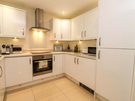 A kitchen with cabinets, oven, and microwave at Heulfan in Conwy