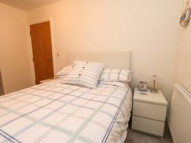 A bedroom with a bed and nightstand at Heulfan in Conwy