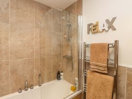 A bathroom with a shower and bathtub at Heulfan in Conwy