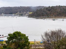 A landscape view of a river with boats and a bridge at Heulfan in Conwy