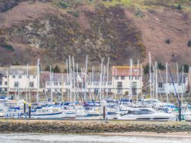 A marina with boats and houses near the shore at Heulfan in Conwy
