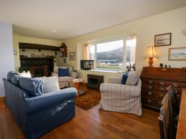 A living room with a sofa, armchair, television and decorative items at Bryncyn in Newport, Pembrokeshire