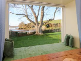 A seating area with cushions and window view at Bryncyn Newport, Pembrokeshire