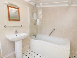 A bathroom with a bathtub, sink, and mirror at Bryncyn in Newport, Pembrokeshire