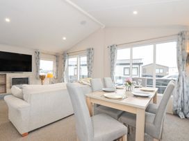 A living room with a dining area and a television at 2 Summerleaze in Bude