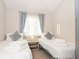 A bedroom with two single beds and a bedside table at 2 Summerleaze in Bude