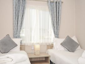 A bedroom with beds and a lamp at 2 Summerleaze Bude