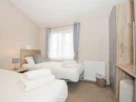 A bedroom with two beds and a wardrobe at 2 Summerleaze in Bude